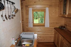 una cucina con lavandino e una finestra in una cabina di Gorska hiška Vogar nad Bohinjskim jezerom a Bohinj