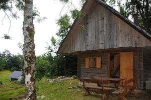 Gorska hiška Vogar nad Bohinjskim jezerom في بوينج: كابينة خشب أمامها طاولة