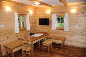 uma sala de jantar com uma mesa e uma televisão em Gorska hiška Vogar nad Bohinjskim jezerom em Bohinj