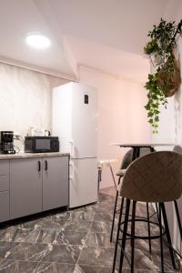 une cuisine avec un réfrigérateur blanc et une table dans l'établissement Snowdrop Apartment, à Sinaia