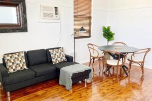 a living room with a couch and a table at Fieldsend Cottage in East Maitland