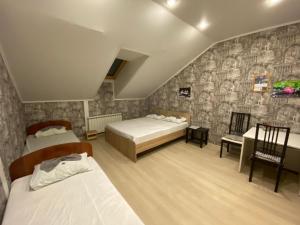 a bedroom with two beds and a stone wall at Hostel Saracen on Bolshaya Krasnaya in Kazan
