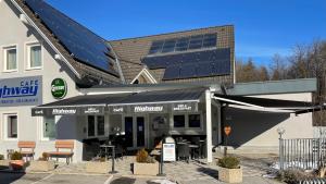 un restaurante con paneles solares en el lateral de un edificio en Hotel Highway - Bed & Breakfast, en Lieboch