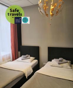 two beds in a room with a sign that says safe travels at Kino Hostel on Pushkinskaya in Saint Petersburg
