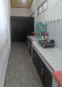 a kitchen with white counter tops and black cabinets at Losmen Ibu Hj. Tarjo in Palembang