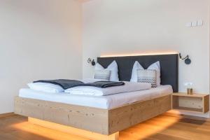 a bedroom with a large bed with a black headboard at Aura Chalets - Nr 3 in Castelrotto