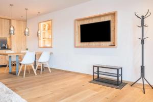 a living room with a table and a tv on a wall at Aura Chalets - Nr 2 in Castelrotto
