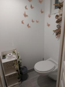 a bathroom with a toilet and butterflies on the wall at Mon Désir in Grand-Fort-Philippe