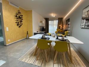 un soggiorno con tavolo e sedie gialle di Promenade Apartments by Quokka 360 - modern apartments of design a Paradiso