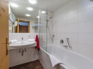 a bathroom with a tub and a sink and a shower at Hotel Harfenwirt in Niederau +32 photos