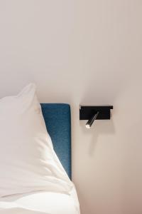 een bed met een wit kussen en een zwarte plank bij ROXI Residence Gent in Gent