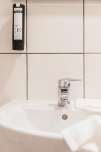 a bottle of soap sitting on top of a bathroom sink at ROXI Residence Gent in Ghent