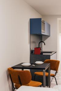 a kitchen with a black table and chairs at ROXI Residence Gent in Ghent