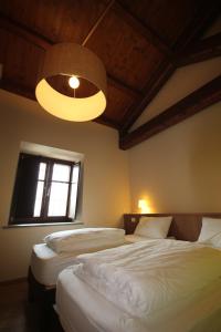1 dormitorio con 2 camas y lámpara. en Agriturismo Tetto Garrone, en Cuneo