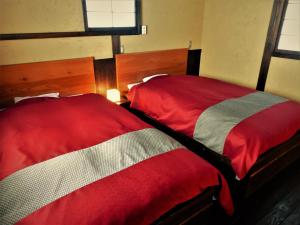 two beds sitting next to each other in a bedroom at Yamakikan in Naganohara