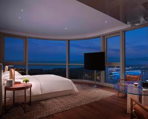a bedroom with a bed and a large window at Andaz Shenzhen Bay in Shenzhen
