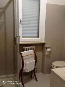 a bathroom with a toilet and a mirror and a chair at B&B I Sassetti in Foligno +32 photos