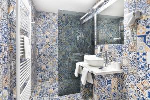 a bathroom with blue and white tiles and a sink at Hotel Atlantis in Brno