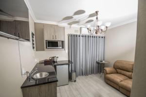 a small kitchen and living room with a couch at Up21 Guest House in Boksburg