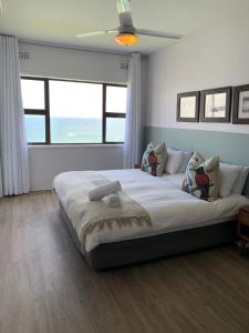 a bedroom with a large bed with a large window at Umdloti Cabanas in Umdloti