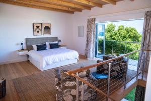 a bedroom with a bed and a balcony at Cape Beach Villa in Noordhoek +50 photos