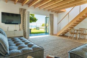 a living room with a couch and a television at Cape Beach Villa in Noordhoek