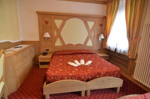 a bedroom with a bed with a book on it at Hotel Cristallo in Andalo