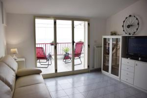 Il comprend un salon avec un canapé, une télévision et un balcon. dans l'établissement Ionio Sea Apartment, à Marina di Gioiosa Ionica