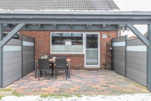 フリードリッヒシュコオク・シュピツェにあるFerienhaus Kikkiの家の前にテーブルと椅子が置かれたパティオ