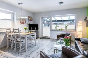 フリードリッヒシュコオク・シュピツェにあるFerienhaus Kikkiのテーブルと椅子のあるキッチンとリビングルーム +14枚の写真