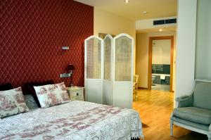 メディナ・デ・リオセコにあるHospedium Hotel Vittoria Colonnaの赤い壁のベッドルーム1室(ベッド1台付)