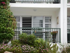 a white house with a balcony with flowers at dk villas 4 Riverview, Hout Bay in Hout Bay