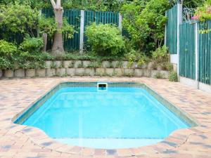 una piscina en un patio con una valla en dk villas 4 Riverview, Hout Bay en Hout Bay