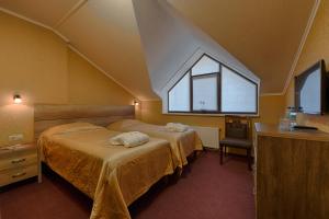 um quarto com 2 camas e uma janela em Hotel Riders Equides club em Lesniki