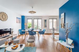 a living room with blue walls and a table and chairs at L'Echo des Vagues in Saint Malo