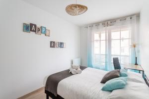 Un dormitorio con una cama con un osito de peluche. en L'Echo des Vagues, en Saint-Malo