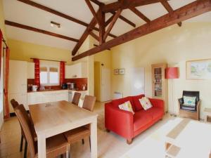 - un salon avec un canapé rouge et une table dans l'établissement Charming 2-Bed House in Les Forges with pool, à Les Forges