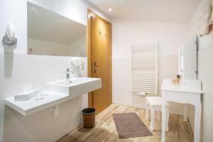 a white bathroom with two sinks and a mirror at Appartement Frühstückspension Landhaus Karwendel in Pertisau +101 photos