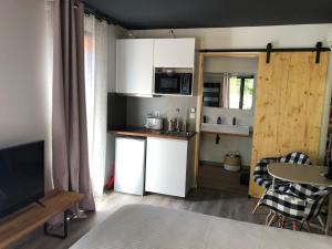 a small kitchen with white cabinets and a table with chairs at Villa Andernos in Andernos-les-Bains