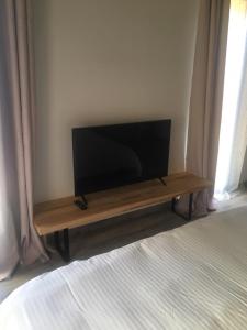 - une télévision à écran plat assise sur une table en bois dans une chambre dans l'établissement Villa Andernos, à Andernos-les-Bains
