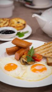 un plato de huevos, salchichas y tostadas en una mesa en Алатау, en Shchūchīnsk