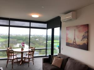 ein Wohnzimmer mit einem Sofa und einem Tisch mit Aussicht in der Unterkunft Parkview Modern Apartment w Parking @ Olympic Park in Sydney