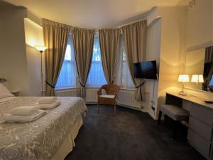 ロンドンにあるザ ゲートウェイ ホテルのベッドとテレビが備わるホテルルームです。
