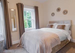 a bedroom with a large bed and a window at Gate Keepers Cottage in Easington
