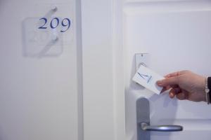 a person is holding a piece of paper in front of a door at Aurea Hotel in Tortoreto Lido