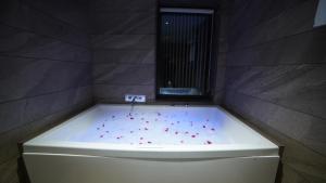 a bath tub with red sprinkles in a bathroom at Bodhi A Boutique Hotel Kumbhalgarh in Kumbhalgarh