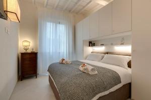 ein Schlafzimmer mit einem großen Bett mit zwei ausgestopften Tieren darauf in der Unterkunft Mamo Florence - Brancacci Suite in Florenz