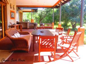 a patio with a wooden table and chairs at Chumbi Bush House in Hluhluwe
