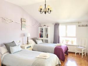 a bedroom with two beds and a chandelier at La Aldaia de Urbasa in Eulate