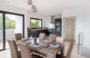 a kitchen and dining room with a wooden table and chairs at VILLA TORRACCIA 4 Étoiles in Sainte-Lucie de Porto-Vecchio